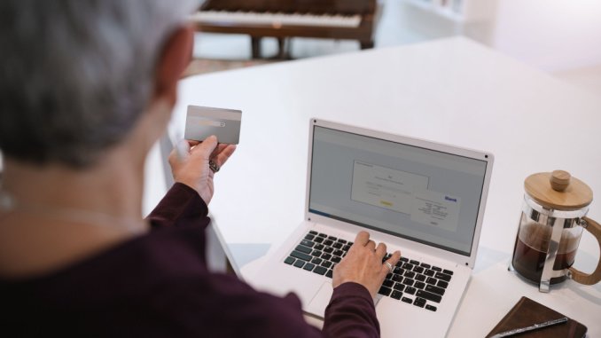 elderly woman with credit card and laptop