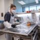 Intern Abigail Brown assists in cleanup after an exam at the Pinal County Medical Examiner's Office on Aug. 4, 2023. [Bryan Mordt]