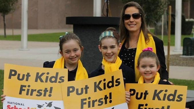 Shawnna Bolick with kids holding signs