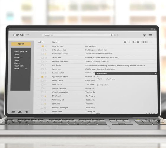 Image of a laptop screen showing a full email inbox with multiple subject lines and emails.