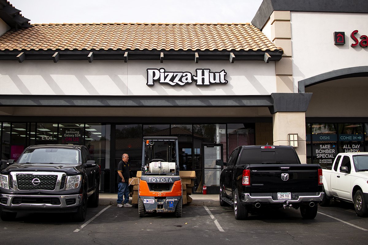 A contractor stands outside Pizza Hut's new location, a suite just between Say Sushi and T-Mobile on John Wayne Parkway, on Nov. 27, 2024. [Monica D. Spencer]