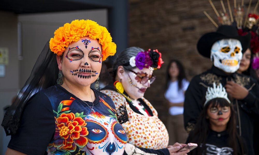 A row of participants wearing face paint, masks and flower crowns wait for the results of a Catrina contest on Nov. 2, 2024. La Calavera Catrina, or simply La Catrina, is the skeletal figure of a woman dressed elegantly, symbolizing life and death. [Monica D. Spencer]