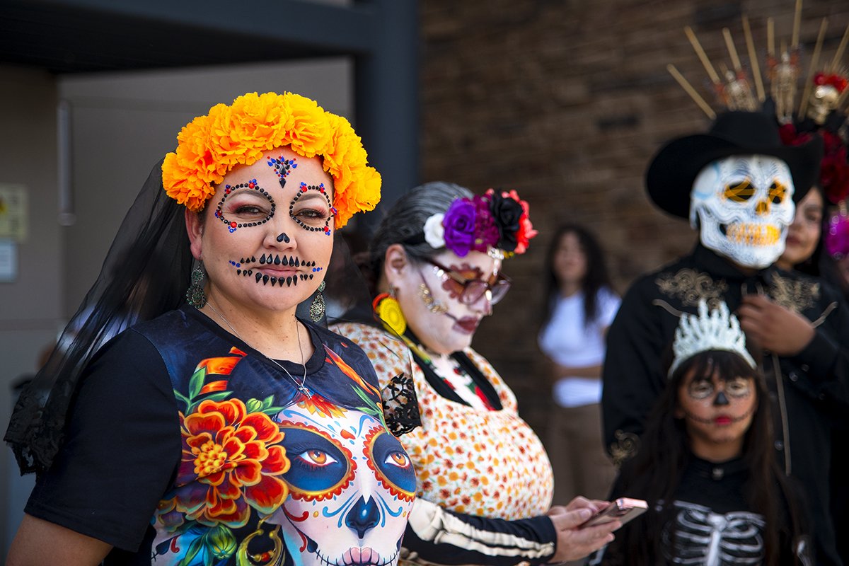 A row of participants wearing face paint, masks and flower crowns wait for the results of a Catrina contest on Nov. 2, 2024. La Calavera Catrina, or simply La Catrina, is the skeletal figure of a woman dressed elegantly, symbolizing life and death. [Monica D. Spencer]