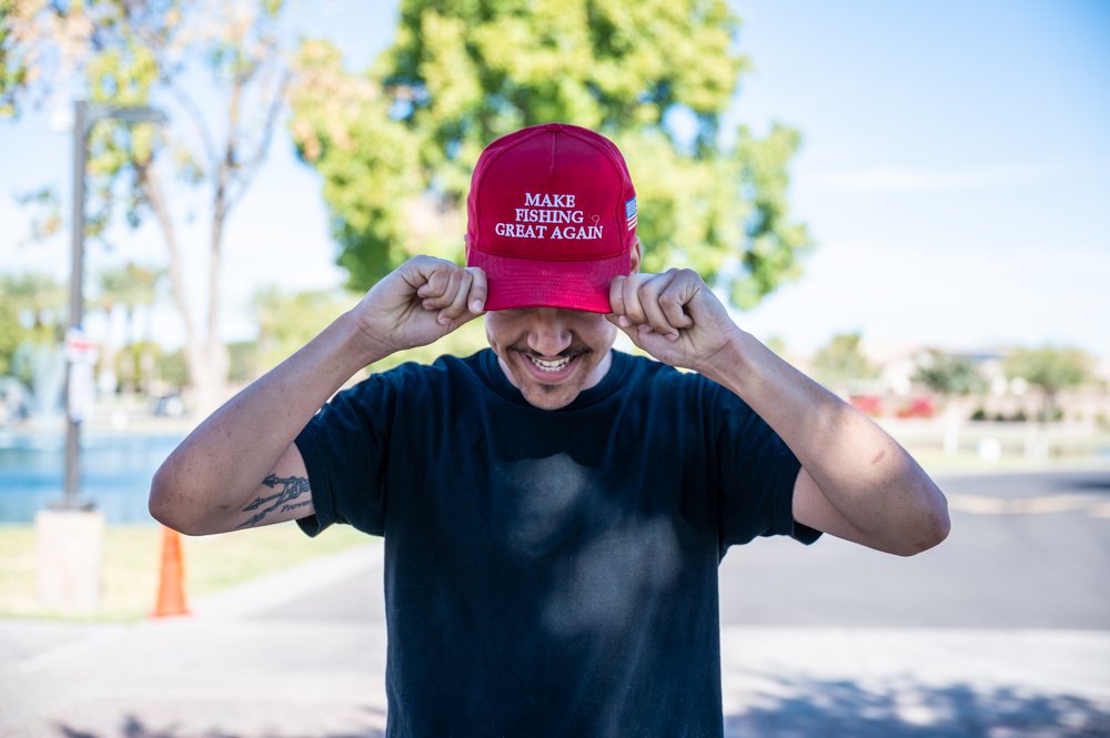 A man shows off a red hat reading "make fishing great again" outside a polling station in Maricopa on Nov. 5, 2024. [Bryan Mordt]