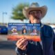 Andy Opary holds a card supporting T.J. Shope, Teresa Martinez and Chris Lopez outside a polling station in Maricopa on Nov. 5, 2024. [Bryan Mordt]