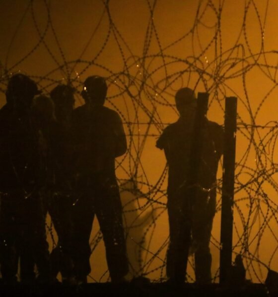 Migrants wait throughout the night on May 10, 2023, in a dust storm at Gate 42, on land between the Rio Grande and the border wall, hoping they will be processed by immigration authorities before the expiration of Title 42. (Photo by Corrie Boudreaux for Source New Mexico)