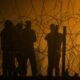 Migrants wait throughout the night on May 10, 2023, in a dust storm at Gate 42, on land between the Rio Grande and the border wall, hoping they will be processed by immigration authorities before the expiration of Title 42. (Photo by Corrie Boudreaux for Source New Mexico)