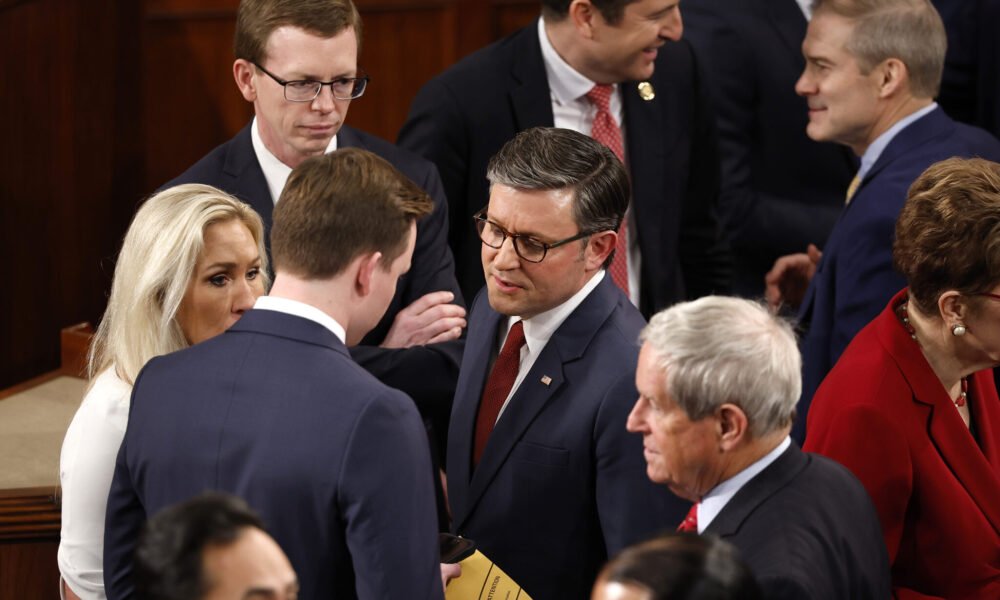 U.S. Rep. Mike Johnson, R-La., center, and Rep. Marjorie Tayler Greene, R-Ga., left, talk with fellow representatives as they arrive for the first day of the 119th Congress in the House Chamber of the U.S. Capitol Building on Jan. 3, 2025 in Washington, D.C.  (Photo by Chip Somodevilla/Getty Images)