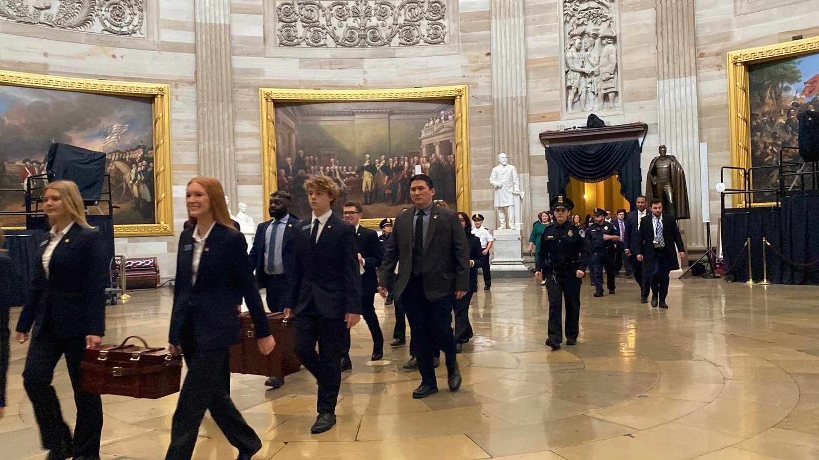 U.S. Senate pages carrying the Electoral College certificates in wooden ballot boxes walk through the Capitol rotunda on their way to the U.S. House chamber on Monday, Jan. 6, 2025. (Photo by Jennifer Shutt/States Newsroom)