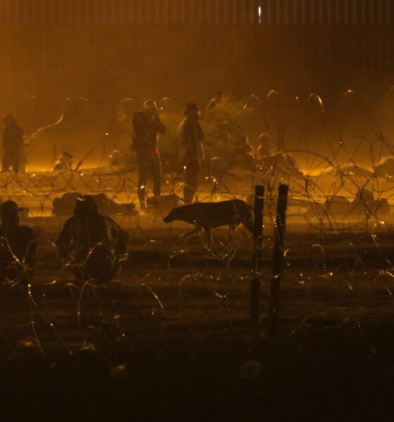 Migrants wait throughout the night May 10, 2023, in a dust storm at Gate 42, on land between the Rio Grande and the border wall. (Photo by Corrie Boudreaux for Source New Mexico)