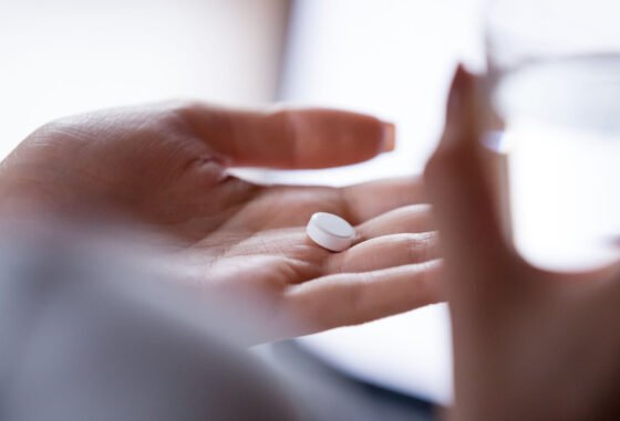 woman's hand holding pill