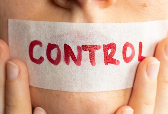 tape on woman's mouth with control written on it