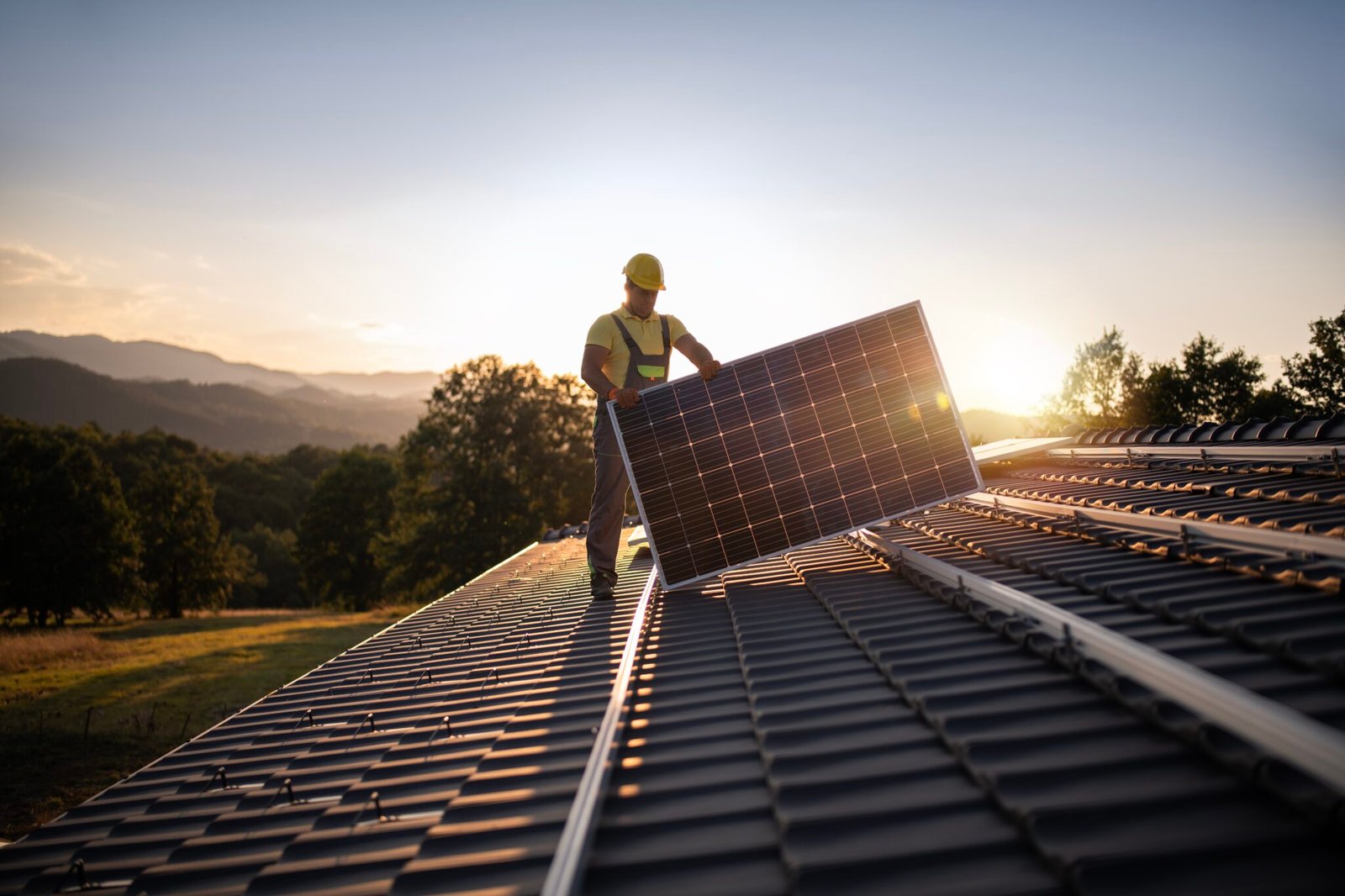 A worker installs a solar panel on a roof. (Getty Images)