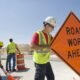 Workers moving equipment and road signs on a highway. (Getty Images)  