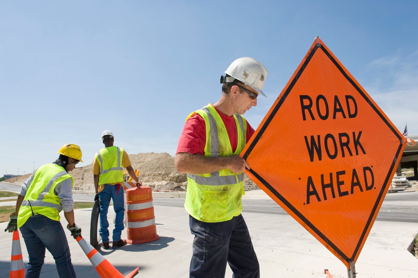 Workers moving equipment and road signs on a highway. (Getty Images)